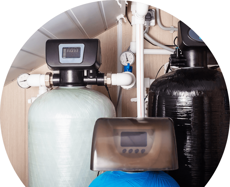 Shines home water filtration system featuring resin tanks, digital control heads, pressure gauges, and connected piping in a utility room. Shines home water filtration system featuring resin tanks, digital control heads, pressure gauges, and connected piping in a utility room.