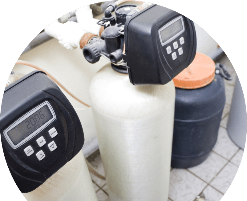 Shines water softener installation showing dual resin tanks with digital control heads and a brine tank in a tiled utility area. Shines water softener installation showing dual resin tanks with digital control heads and a brine tank in a tiled utility area.