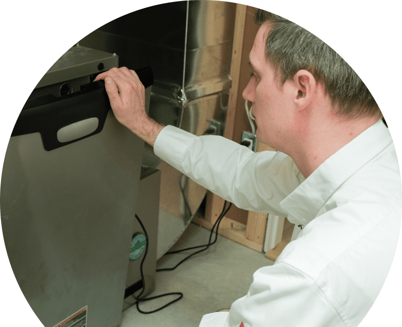 Shines HVAC professional installing a new furnace unit, aligning the front panel with surrounding ductwork and wiring in a residential utility space. Shines HVAC professional installing a new furnace unit, aligning the front panel with surrounding ductwork and wiring in a residential utility space.