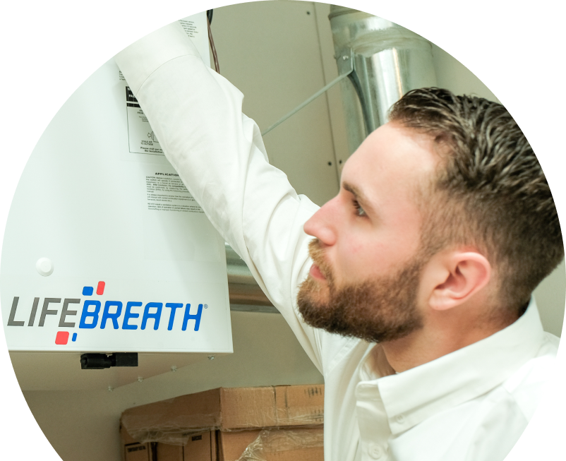 Shines indoor air quality specialist inspects a Lifebreath ventilation unit related to UV air purifiers, with ductwork and boxes in the background. Shines indoor air quality specialist inspects a Lifebreath ventilation unit related to UV air purifiers, with ductwork and boxes in the background.